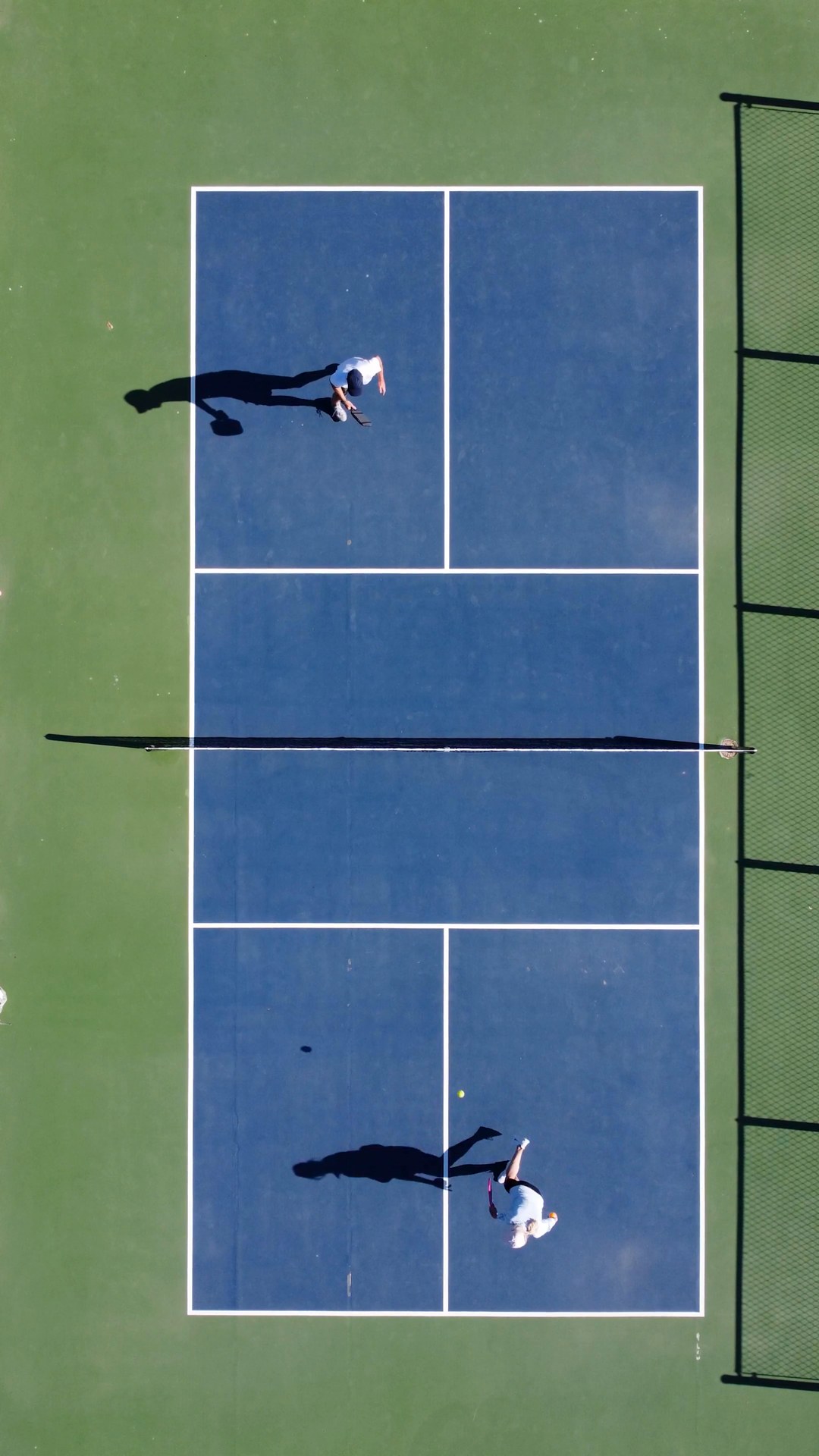 Overhead view of players on a pickleball court.
